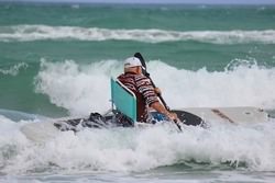Surfing waves while sitting in a comfy beach chair.