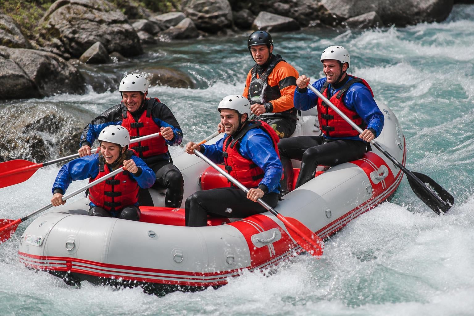 A group of paddlers on a whitewater raft navigating rapids, dynamic action shot showing splashing water and teamwork, il