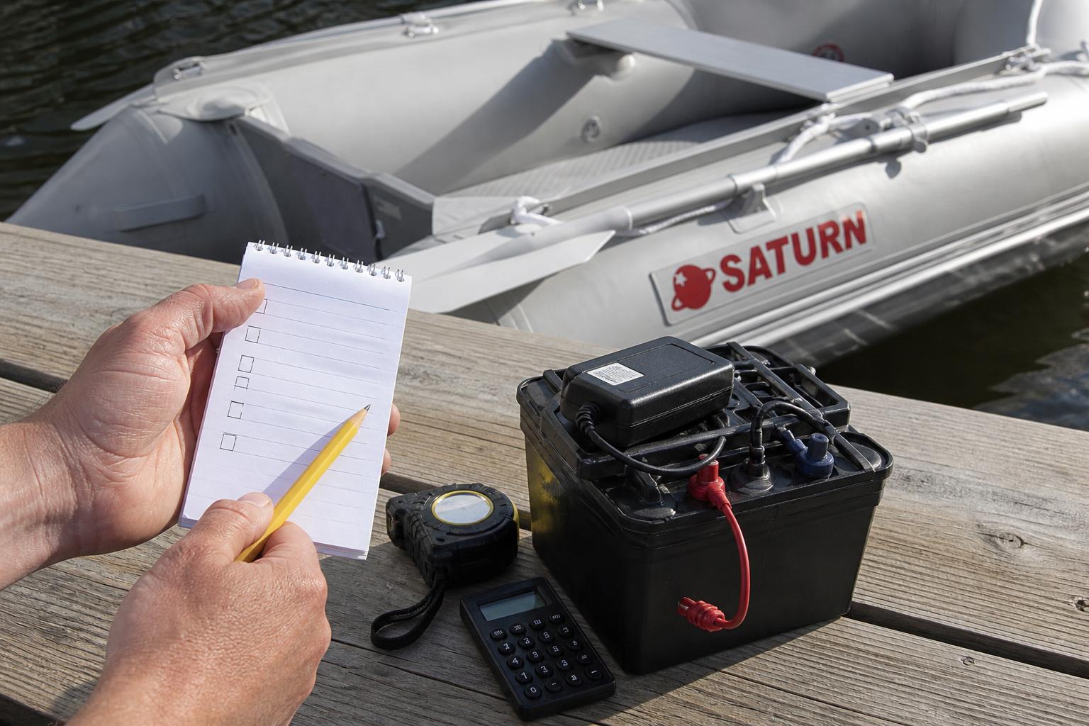 An illustrative checklist scene showing a paddler's hand holding a notepad with a simple sizing checklist, a battery, a 