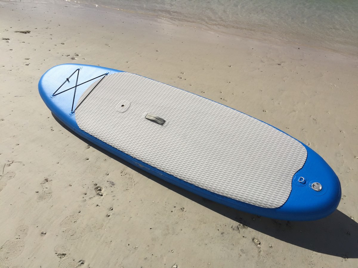 Manufacturer demo of inflatable paddle board with windsurfing sail