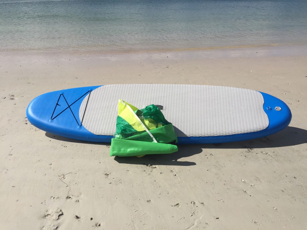 Manufacturer demo of inflatable paddle board with windsurfing sail