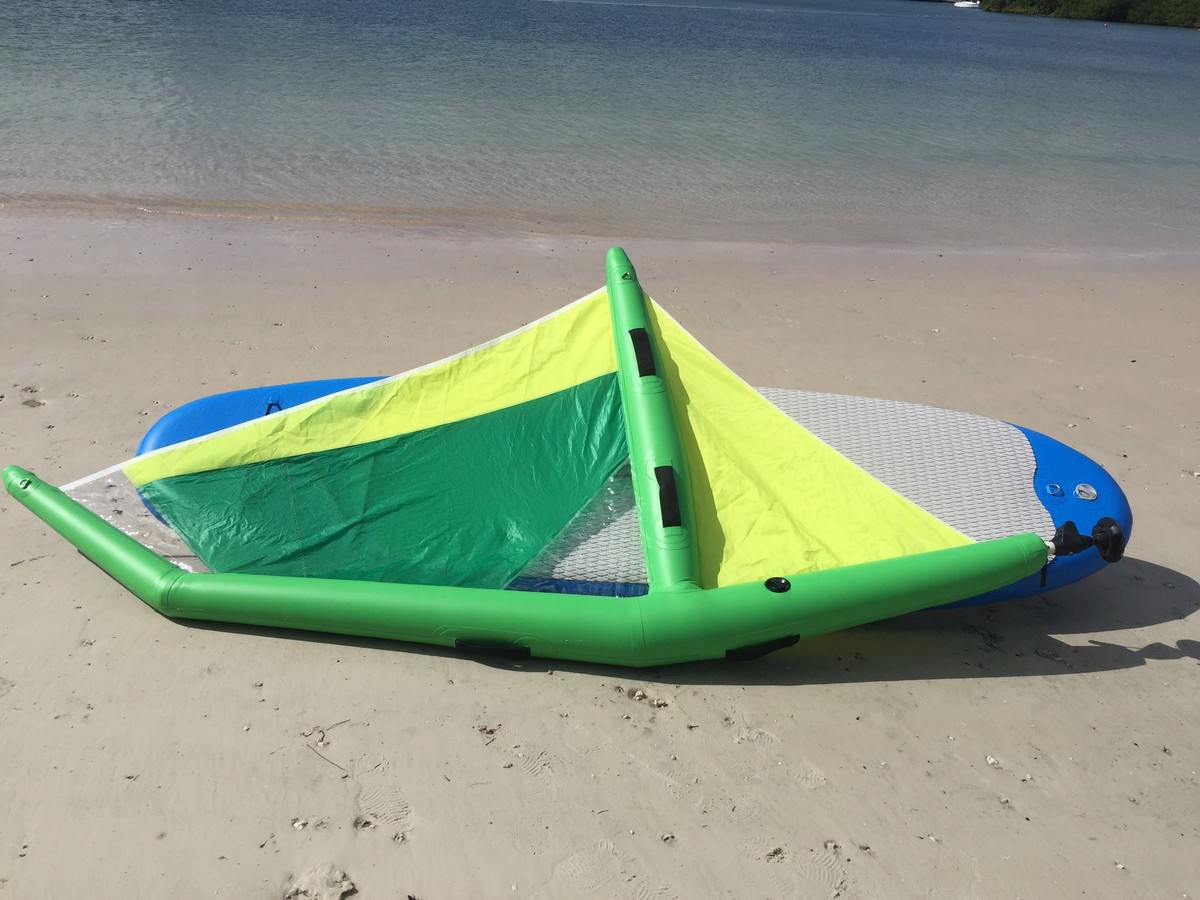 Manufacturer demo of inflatable paddle board with windsurfing sail