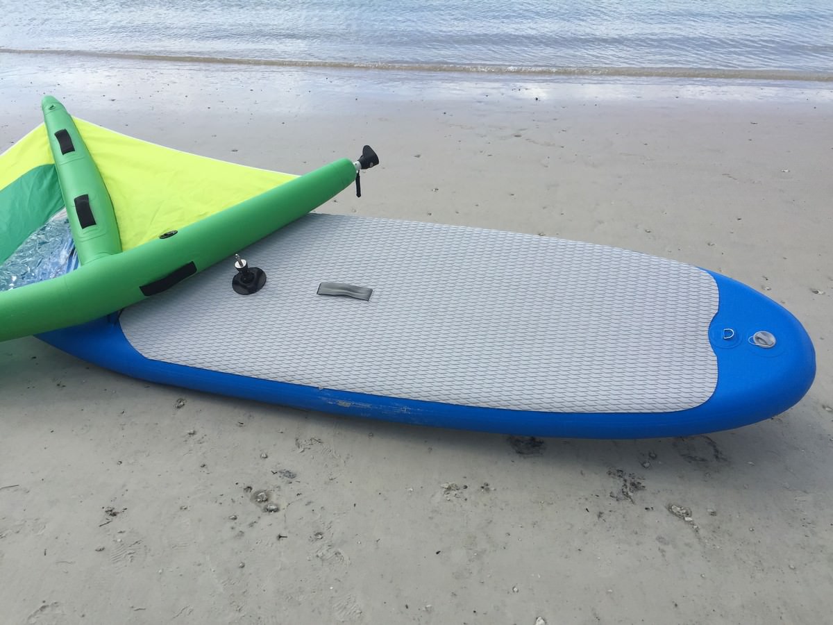 Manufacturer demo of inflatable paddle board with windsurfing sail