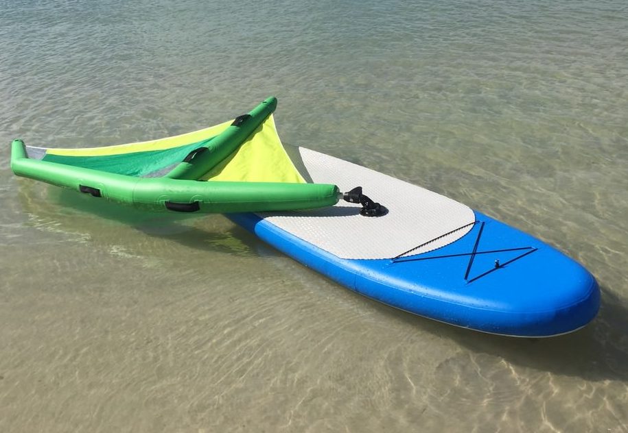 Manufacturer demo of inflatable paddle board with windsurfing sail