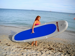 Girl holding inflatable SUP paddle board ready to go paddling