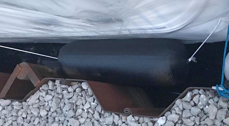 Inflatable fender attached horizontally, to allow roll with tides
