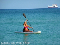 Girl kayaking while sitting on top of inflatable paddel board