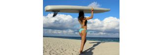 Girl carrying inflatable sup paddle board on a head